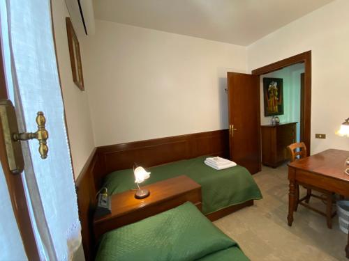 mały pokój z zielonym łóżkiem i stołem w obiekcie Alla Villa Liberty Bed & Breakfast w Weronie