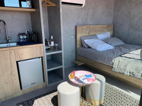 um pequeno quarto com uma cama e uma mesa em Cabane NAOS Aigues- Mortes em Aigues-Mortes