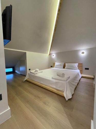 a bedroom with a large bed with white sheets at Agora LX Studios & Suites in Thessaloniki