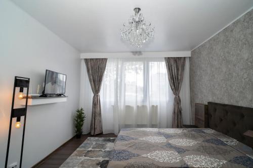 a bedroom with a bed and a chandelier at Garsoniera LUX Drumul Taberei in Bucharest