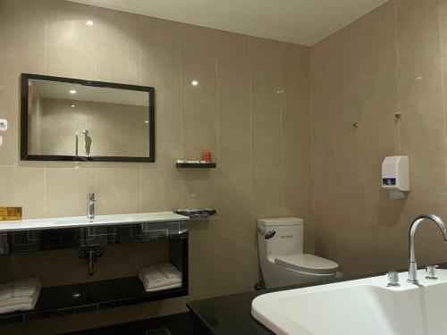 a bathroom with a toilet and a sink and a mirror at Fairy Tale City Motel in Hualien City