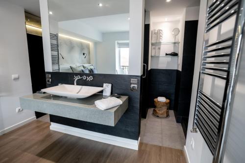 a bathroom with a sink and a large mirror at Hotel Castellote in Castellote