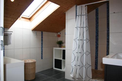 a bathroom with a shower curtain and a sink at Im- Oberland - Berg - KönigsCard in Bad Kohlgrub