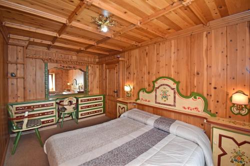 una camera da letto con letto in una camera in legno di CASA LILI DOLOMITI, casa vacanze a Dosoledo a Dosoledo