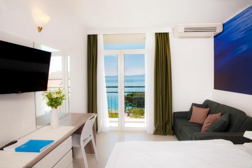 a living room with a couch and a tv at Bluesun hotel Neptun - All inclusive in Tučepi