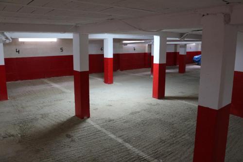 an empty parking garage with red and white columns at Panorama Apartment Nador Jadid Klima Parking Only Family in Nador