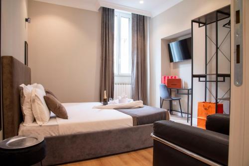 Habitación de hotel con cama y escritorio en AD Suites Tritone, en Roma