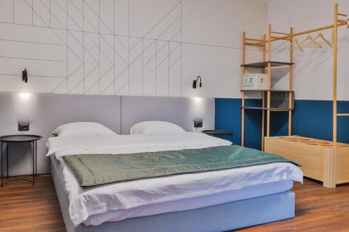 a bedroom with a large bed with blue and white walls at Benelux Hotel in Peje