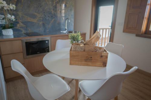een witte tafel met witte stoelen en een houten kist bij Montesinho Eco-Resort in Bragança
