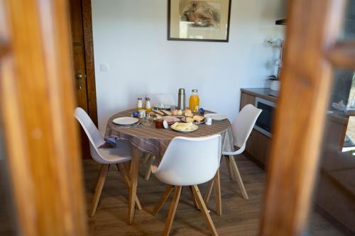 een eettafel met witte stoelen eromheen bij Montesinho Eco-Resort in Bragança