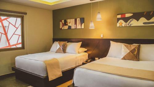 Un pat sau paturi într-o cameră la Remfort Hotel