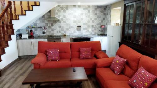 sala de estar con sofá rojo y mesa en O Cobo vacacional en A Coruña