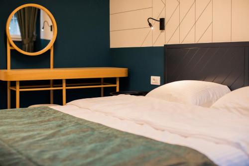 a bedroom with a bed and a mirror at Benelux Hotel in Peje