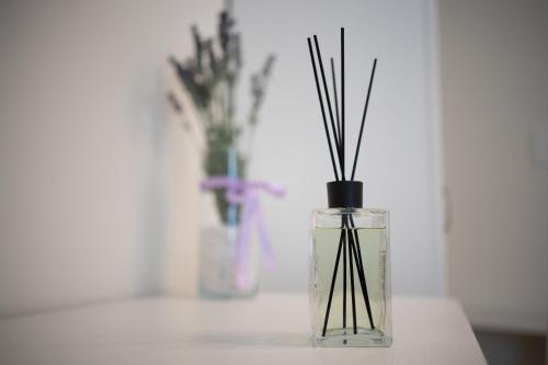 a glass vase with sticks in it on a table at ESSENZA in Massafra