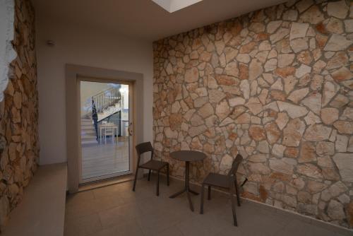 a stone wall in a room with a table and chairs at ESSENZA in Massafra