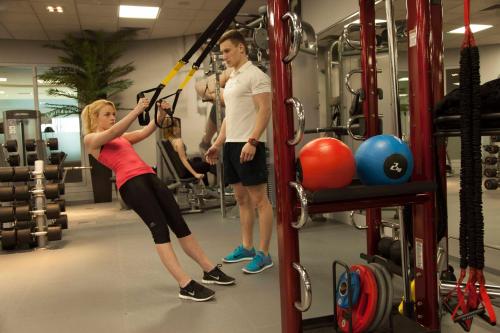 a man and a woman in a gym with a barbell at Crowne Plaza Marlow by IHG in Marlow