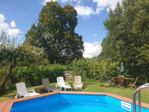 - une piscine dans une cour avec des chaises et une table dans l'établissement Bay Cottage Gite, Busserolles., à Busserolles