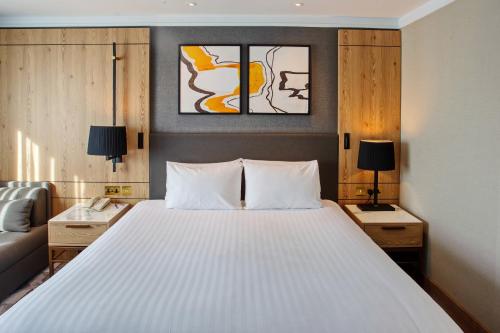 a bedroom with a large white bed and a couch at Crowne Plaza Marlow by IHG in Marlow