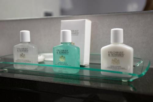 three bottles of detergent sitting on a glass table at Crowne Plaza Marlow by IHG in Marlow