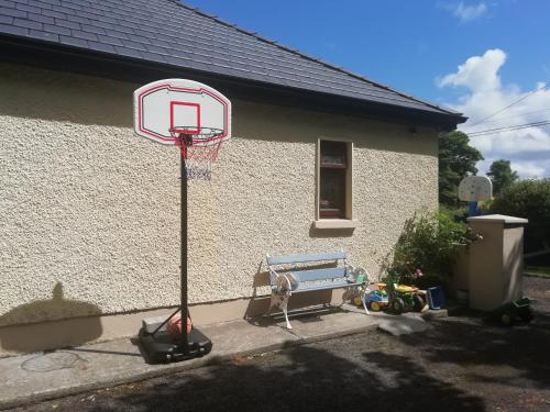 einen Basketballkorb und eine Bank vor einem Haus in der Unterkunft Creevy Annex - 2 bedroom Self Catering Accomodation in Rake Street