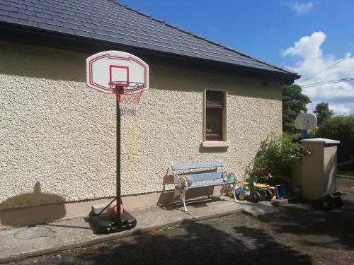 a basketball hoop and a bench in front of a house at Creevy Annex - 2 bedroom Self Catering Accomodation in Rake Street