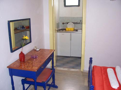 een kamer met een tafel met een vaas erop bij Rose Garden Rooms in Moraitika