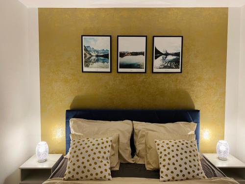 a bedroom with four pictures hanging above a bed at Flat 123 ubytování pod sjezdovkou - Adults only in Deštné v Orlických horách