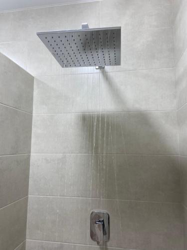 a shower with a shower head with water in it at Уютная квартира, в центре города in Tiraspol