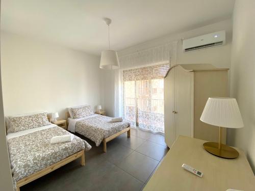 a bedroom with a bed and a table with a lamp at Le Sorelle Apartment in Agrigento