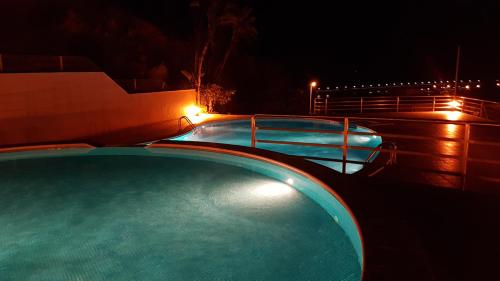 a swimming pool at night with lights on it at Quinta de Palames in Sesimbra
