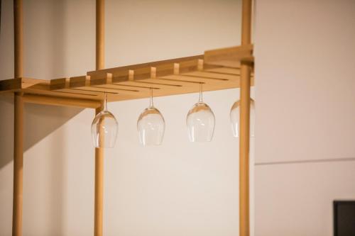 a wooden shelf with four lights hanging from it at Benelux Hotel in Peje