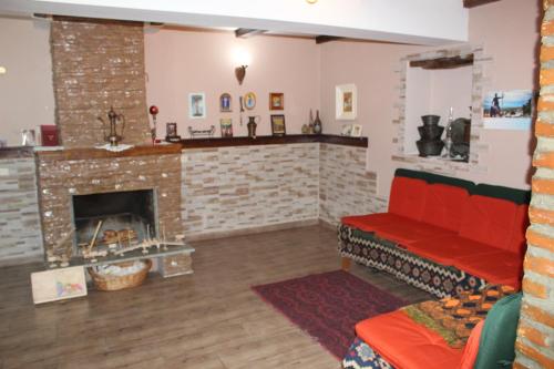 a living room with a red couch and a fireplace at Kera in Tsinandali