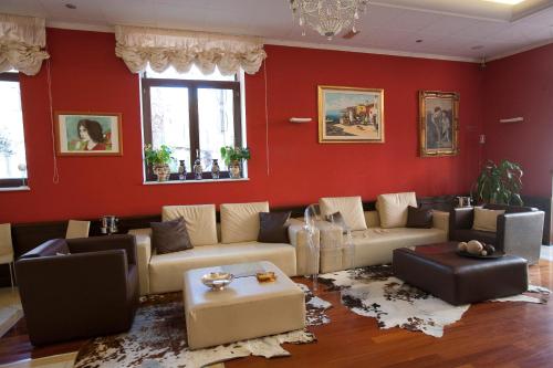 una sala de estar con paredes rojas y sofás en La Chicca Palace Hotel, en Milazzo