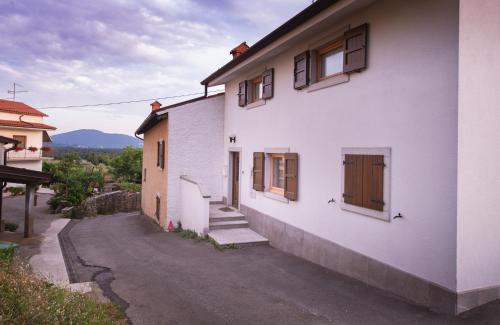 a white building with stairs and windows on it at Hiša Orel (Orel House) in Križ