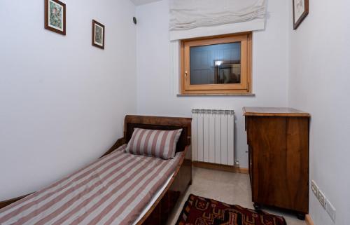 a small bedroom with a bed and a window at Hiša Orel (Orel House) in Križ