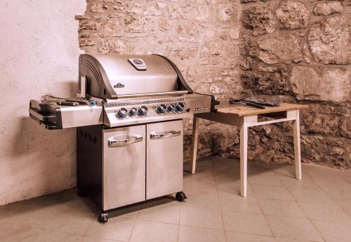 a kitchen with a grill and a wooden table at Hiša Orel (Orel House) in Križ