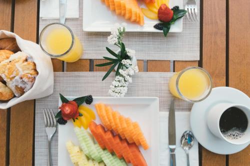 a table with plates of food and glasses of orange juice at Hotel NYX Cancun in Cancún