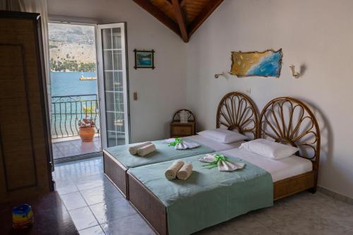 a bedroom with two beds with towels and a balcony at Marina Studios I in Argostoli