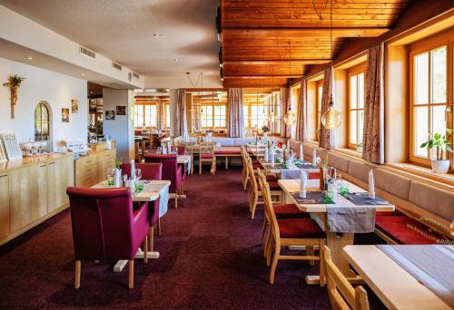 un restaurante con mesas y sillas en una habitación en Natur-Genuss-Hotel Sonnasita en Faschina