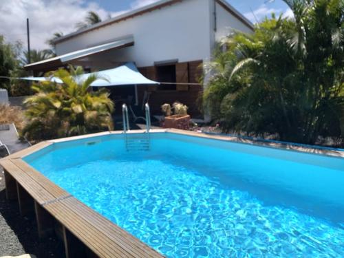 a swimming pool in front of a house at Villa charmante au Moule avec piscine in Le Moule