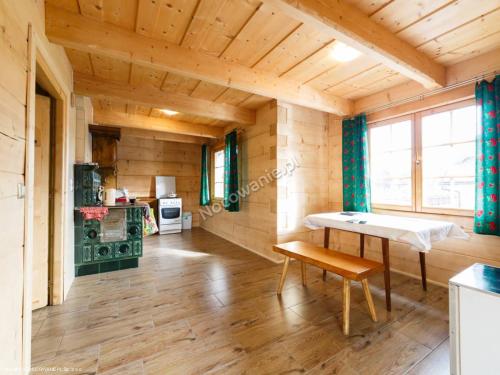 a wooden room with a table and a bench at Chochołowsko-Witowski Wypoczynek in Witów