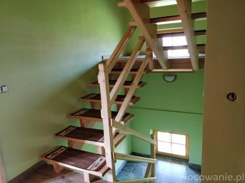 a wooden spiral staircase in a room with green walls at Chochołowsko-Witowski Wypoczynek in Witów