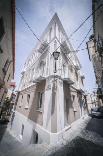 a tall white building with a light on the side of it at Palazzo Paladini - Luxury Suites in the Heart of the Old Town in Pizzo