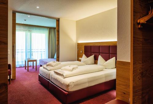 a hotel room with a large bed in a room at Natur-Genuss-Hotel Sonnasita in Faschina