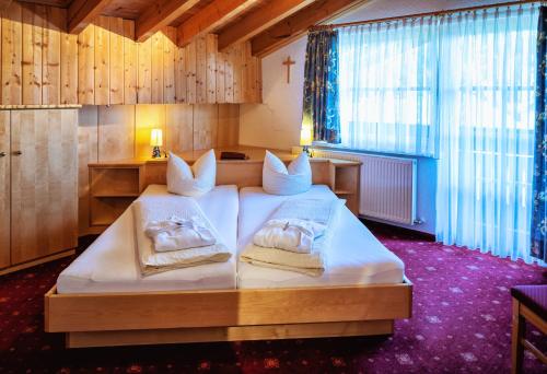 a bedroom with two beds with towels on them at Natur-Genuss-Hotel Sonnasita in Faschina