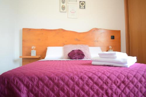 a purple bed with white sheets and towels on it at Angel's Apartment in Funchal