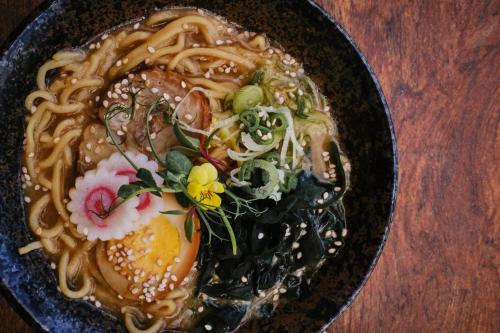 a bowl of food with noodles and vegetables on a table at Hotel NYX Cancun in Cancún