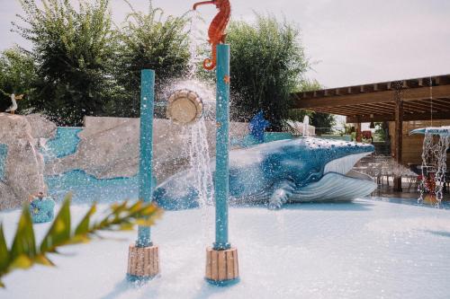a fountain in a water park with a dolphin at Camping Sènia Caballo de Mar in Pineda de Mar
