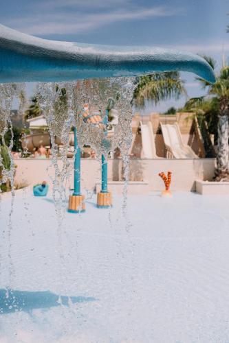 a pool with water pouring out of a water park at Camping Sènia Caballo de Mar in Pineda de Mar