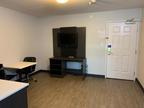 an office with a desk and a tv and a door at Hawthorn Extended Stay by Wyndham Hobbs in Hobbs
